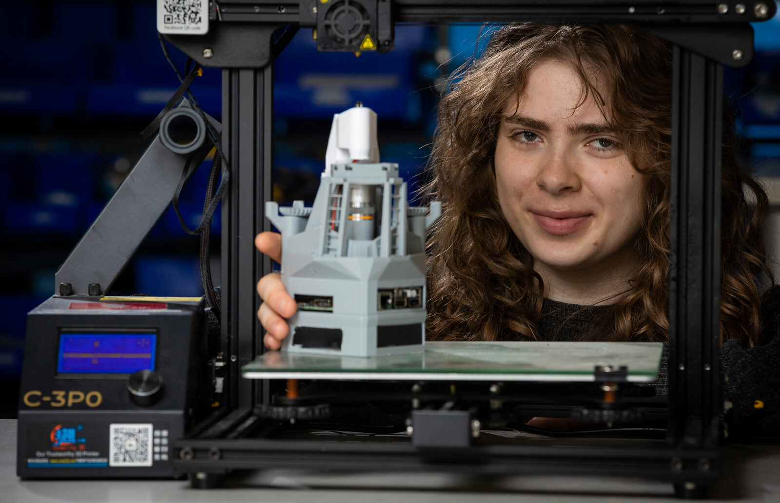 A student with a 3D printer and a printed part